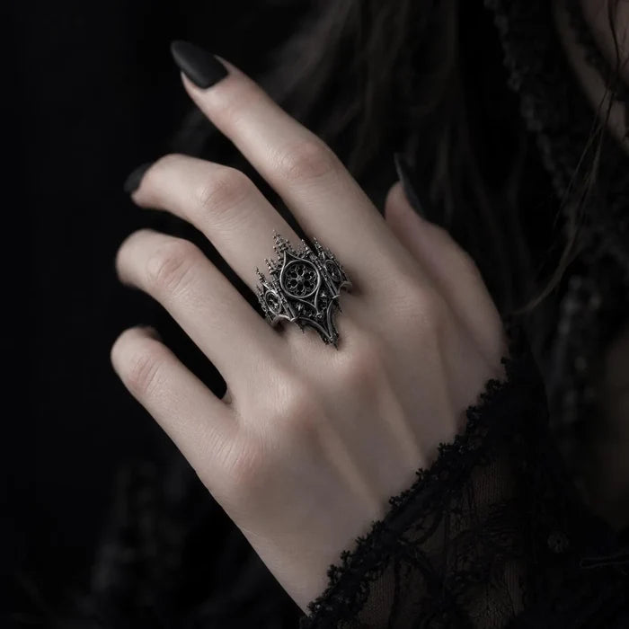 Hand wearing gothic cathedral rose window crown ring — alternative engagement ring with shadow crown silhouette