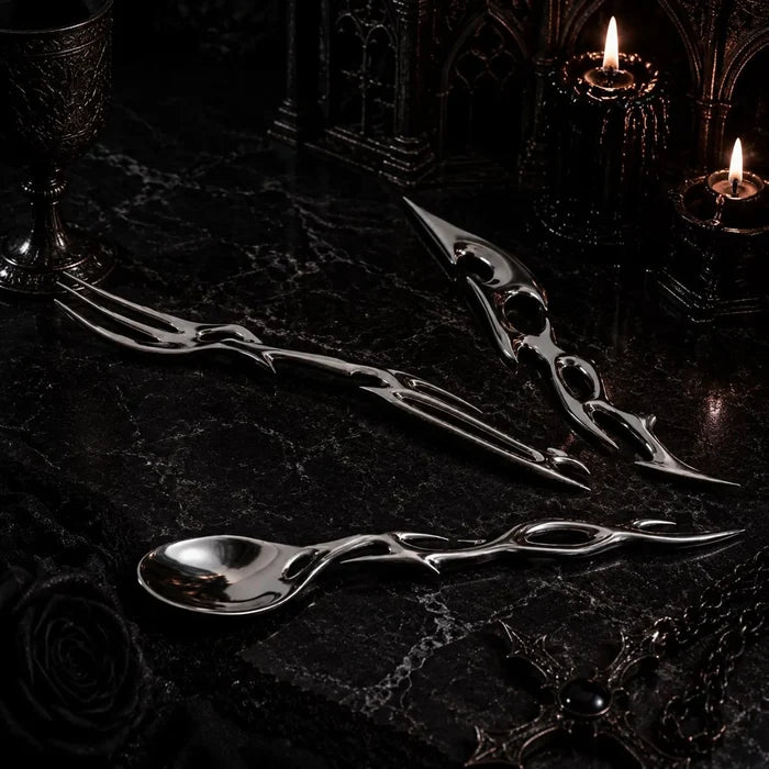 Gothic-futurist luxury flatware set styled on black marble with candlelight — sterling silver spoon, fork and knife