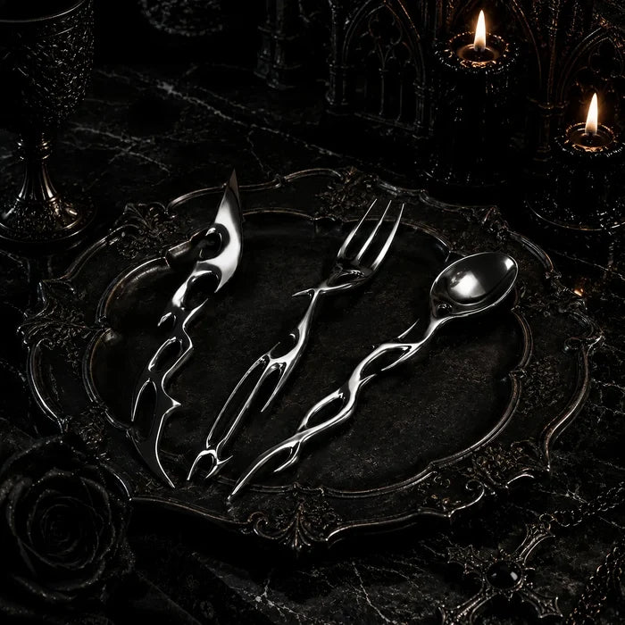 Cyber Baroque spoon, fork and knife arranged on an ornate dark baroque charger plate