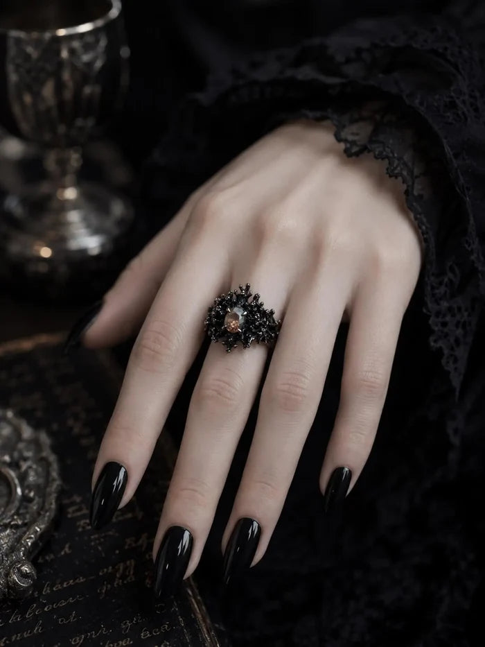 Model wearing the Dark Bloom Ring, a black oxidized sterling silver statement ring with an iridescent oval center stone