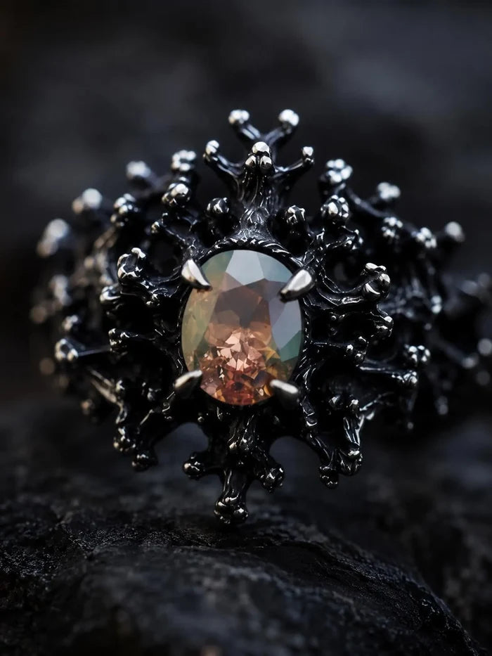 Close-up of the Dark Bloom Ring's blackened thorn-and-coral setting framing the oval gemstone
