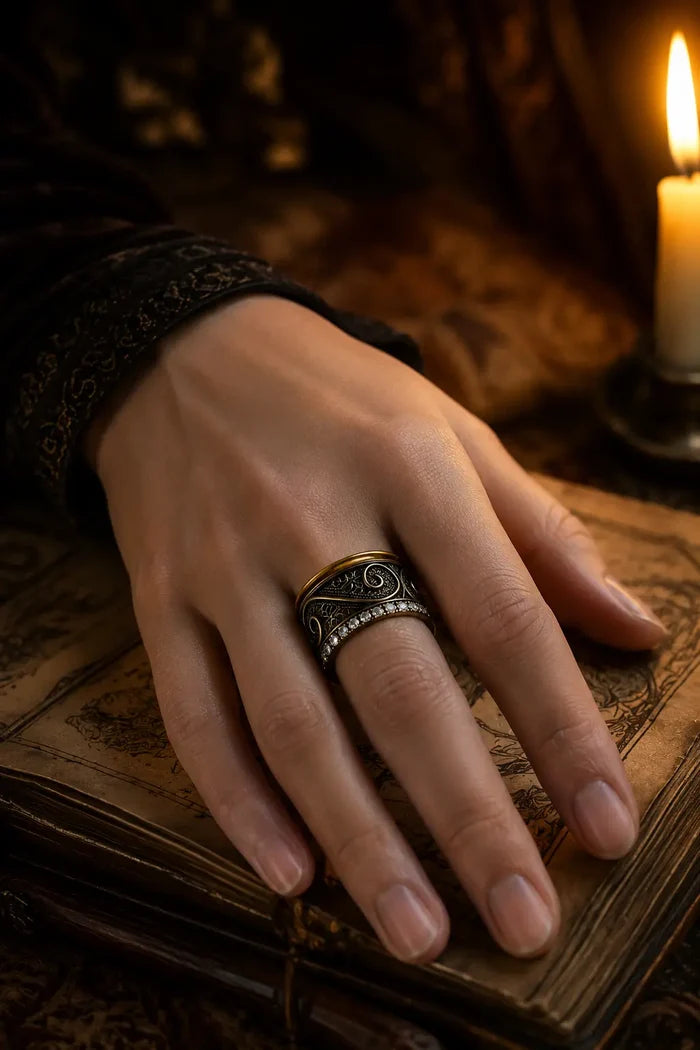 Filigree Pavé Ring worn on hand resting on an antique book beside a candle