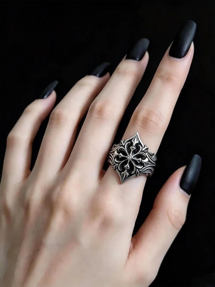 Hand wearing gothic fleur-de-lis cross ring — alternative wedding band with moissanite stone, sterling silver