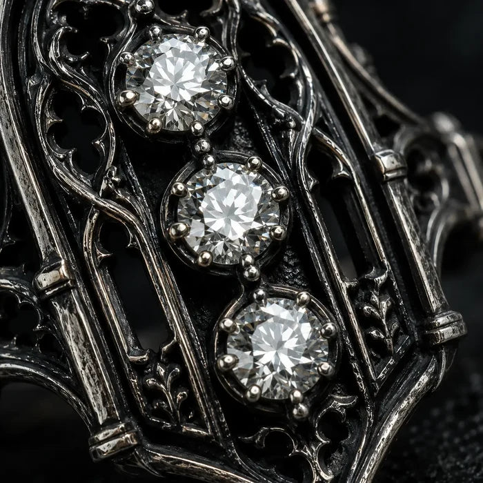 Close-up of an ornate metal object with three diamonds embedded in it. moissanite, Victorian, oxidized silver