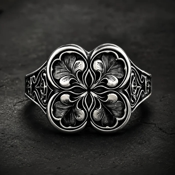 Gothic clover ring — sterling silver quatrefoil engraving, front view on dark stone backdrop