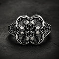 Gothic clover ring — sterling silver quatrefoil engraving, front view on dark stone backdrop