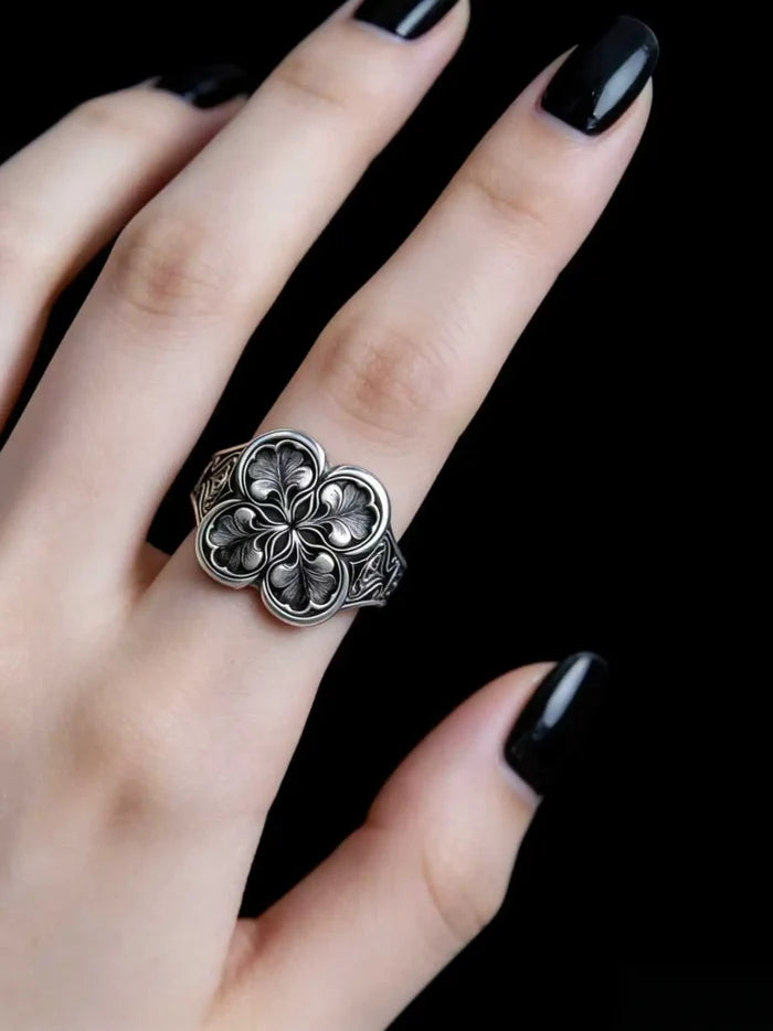 Hand wearing gothic sterling silver clover ring — dark romantic statement jewelry