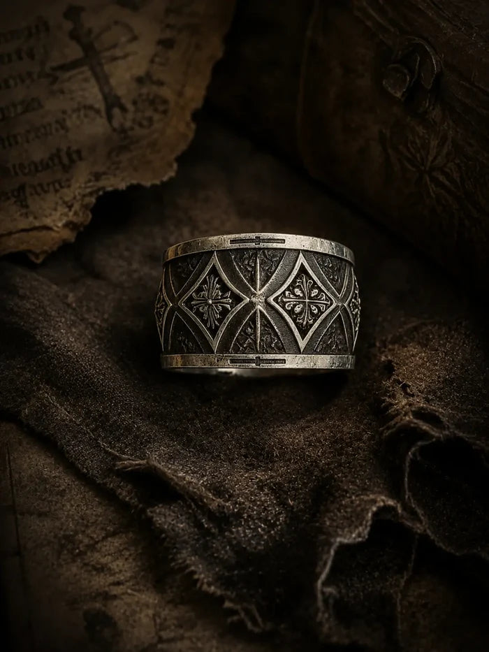 Gothic cross armor band close-up — interlocking pointed arches and deeply recessed cross motif in sterling silver