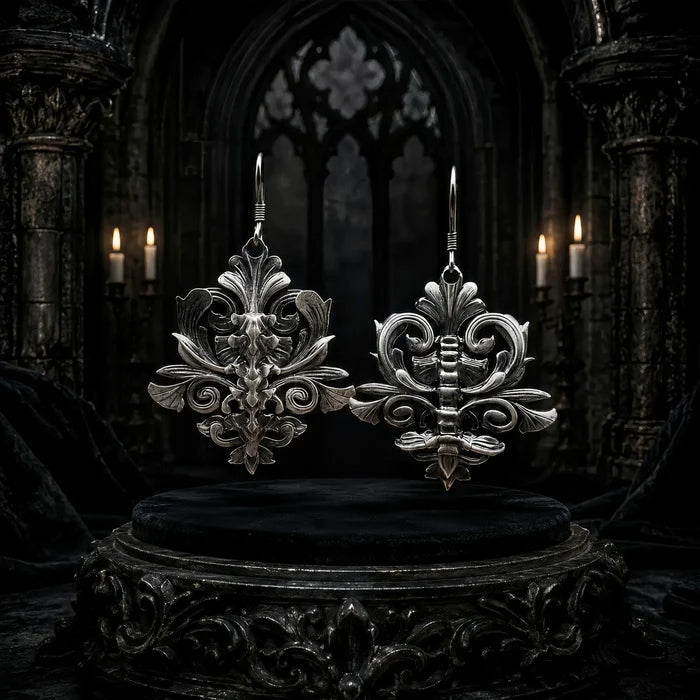 Iris & Spine mismatched gothic dangle earrings, oxidized sterling silver, displayed together on dark stone
