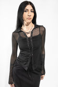 Woman wearing a black long-sleeve top with sheer panels on a white background