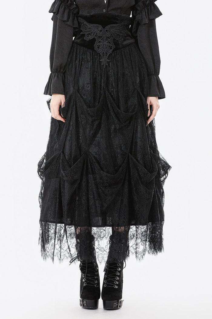 Person wearing a black gothic-style dress with lace details on a white background