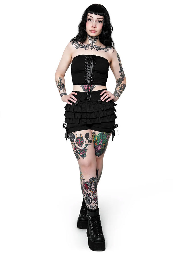 Person wearing a black outfit with floral tattoos on a white background