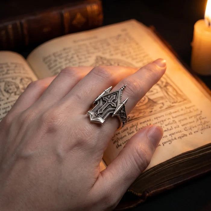 Spire Cross Ring displayed in an antique wooden ring box beside candlelight