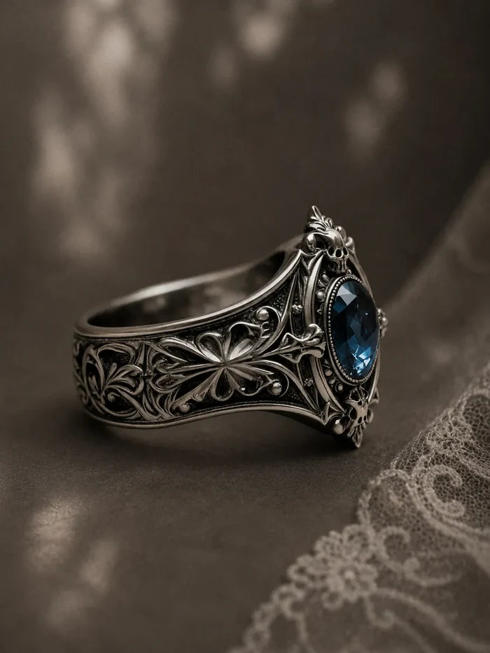 Memento mori skull ring — oval-cut London blue topaz in milgrain bezel, gothic traceries in sterling silver